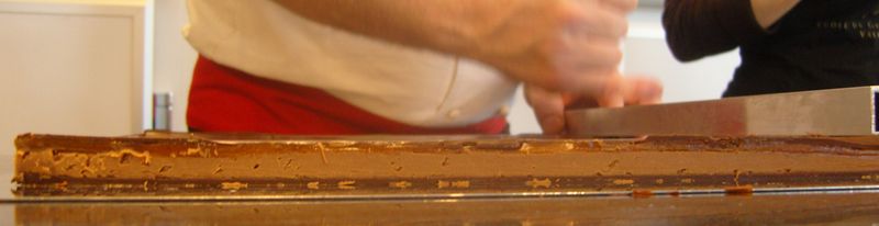 Caramel praliné montée de sa ganache earl grey aux fleurs bleues surmontés d'un glacage au chocolat en cours